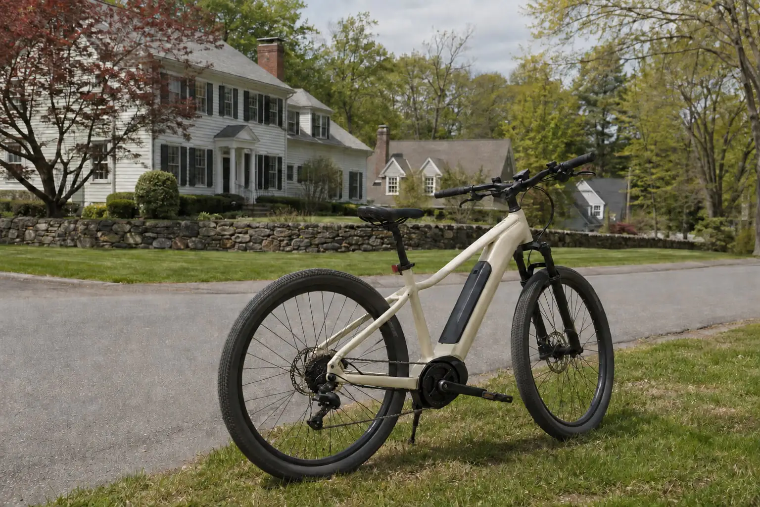 Electric-assist bicycle beside colonial homes, lawns and a stone wall, illustrating Rockland County NY.