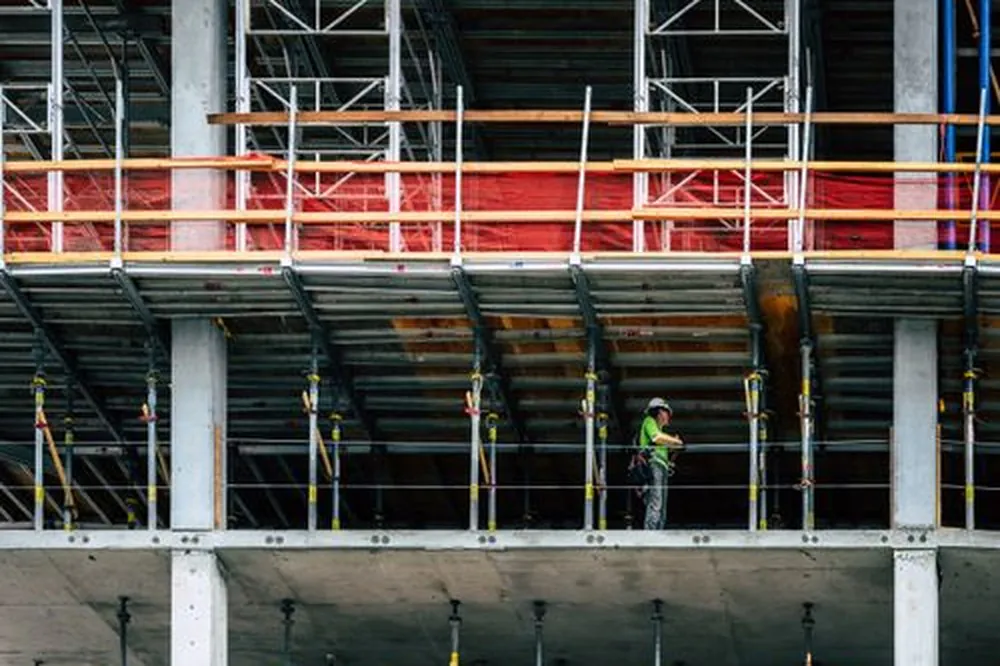 High-rise construction site with a worker on scaffolding