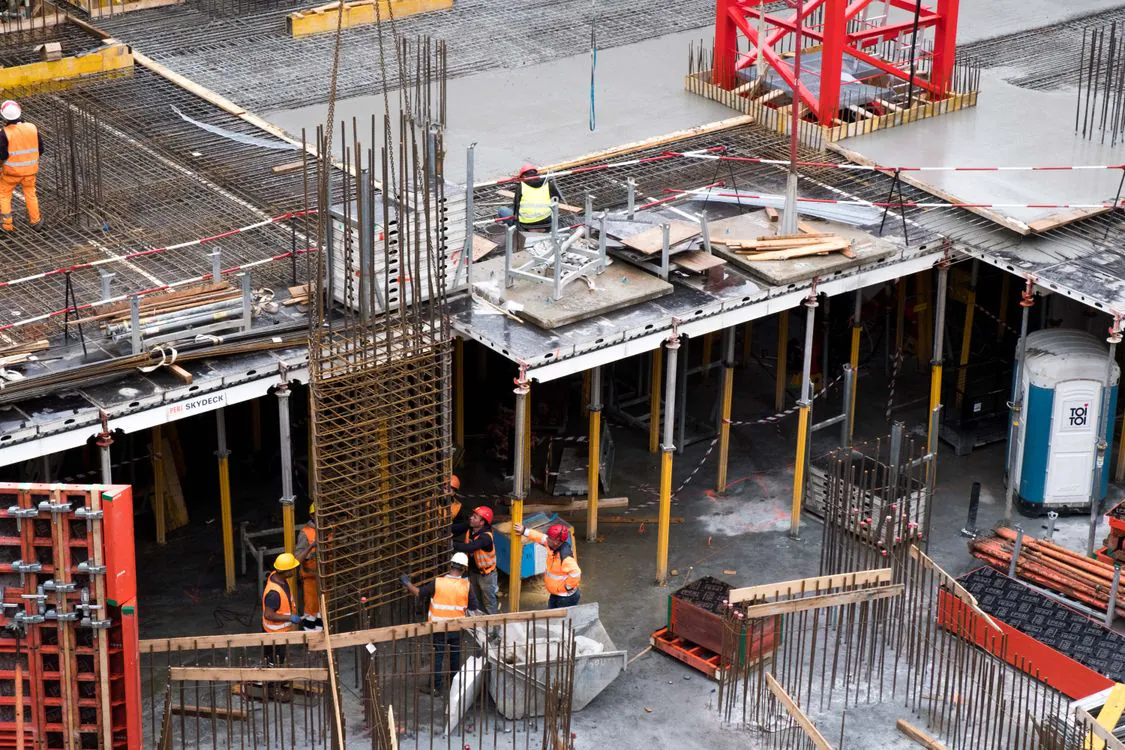 Construction workers erecting a steel frame at a city building site