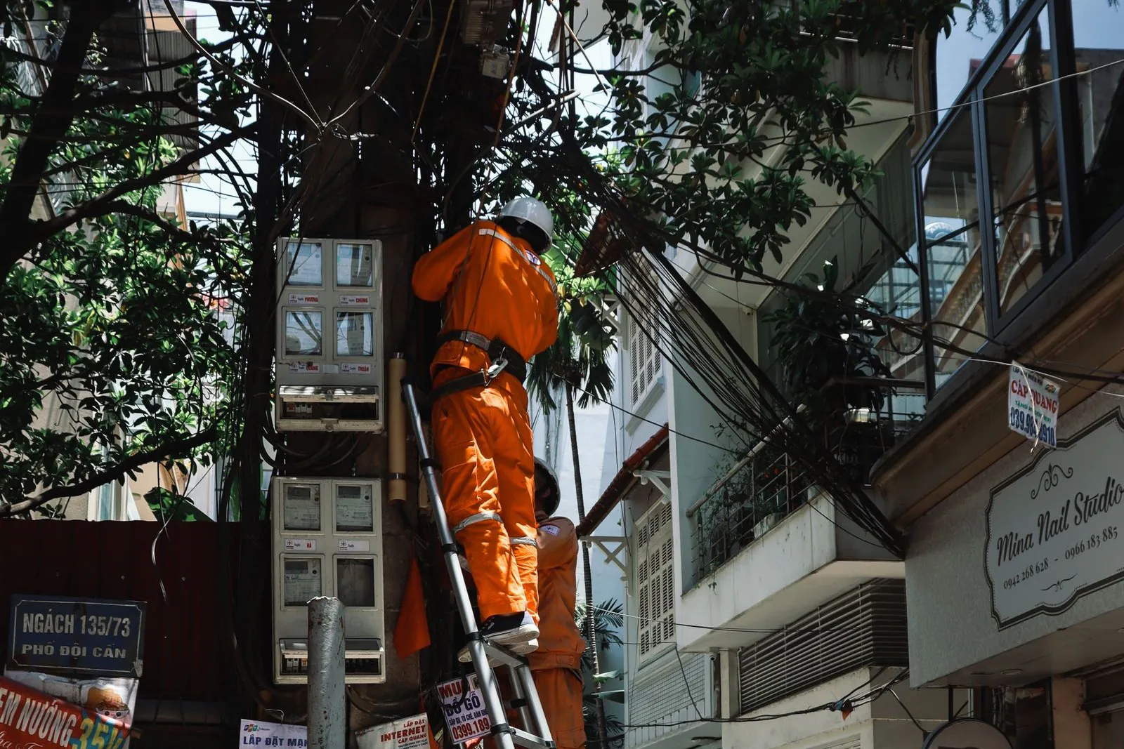 Construction worker in a safety harness standing on an extension ladder