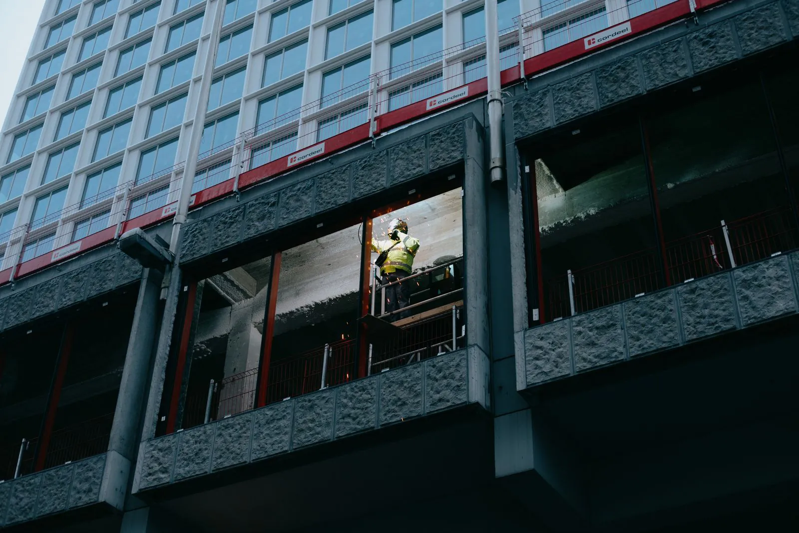 Construction worker on scaffolding on a modern high-rise building facade