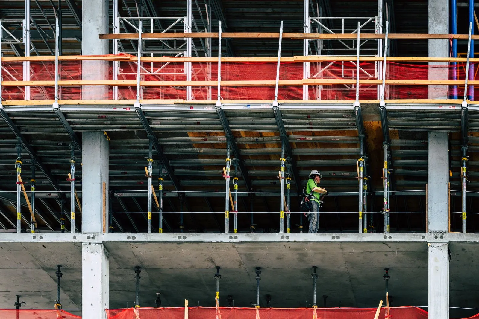 High-rise construction site with a worker on scaffolding